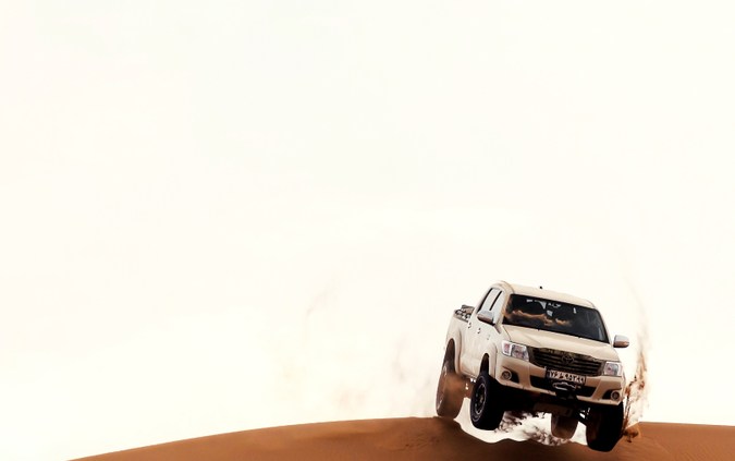 Toyota Hilux 2021 salta desde la cima de una duna de arena en el desierto del Sahara o Dasht e Lut