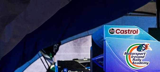 Coches Rally1 Hyundai y Ford Puma en parque de asistencia WRC, con logos Castrol y M-Sport, preparación rally.