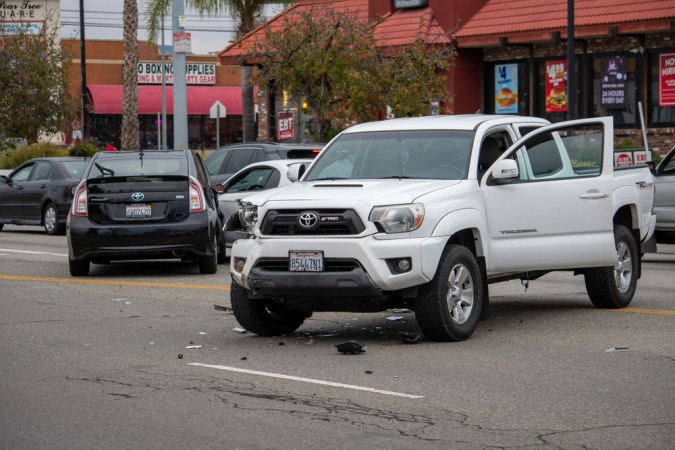 Un camión blanco Toyota Tacoma está en medio de la carretera tras un accidente frente al 6750 de Balboa Blvd, visto desde el frente.
