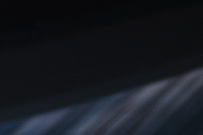 Hombre con cable de alimentación en la estación de carga del vehículo eléctrico, cierre