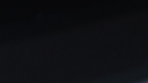 Hombre con cable de alimentación en la estación de carga del vehículo eléctrico, cierre