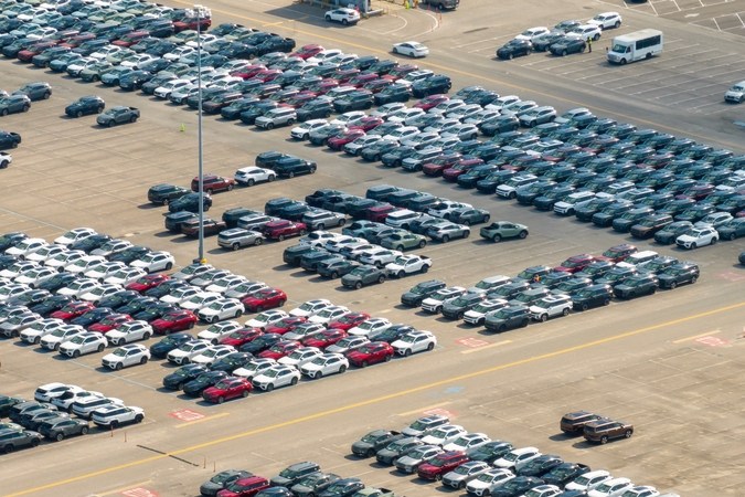 Coches Nuevos estacionados en el estacionamiento automotriz de la fábrica para la exportación mundial. Negocio de inventario de vehículos del concesionario comercial