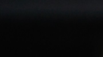 Primer plano de la mano de un mecánico sosteniendo nuevas bujías contra el fondo de un automóvil y el capó abierto. Enfoque selectivo.