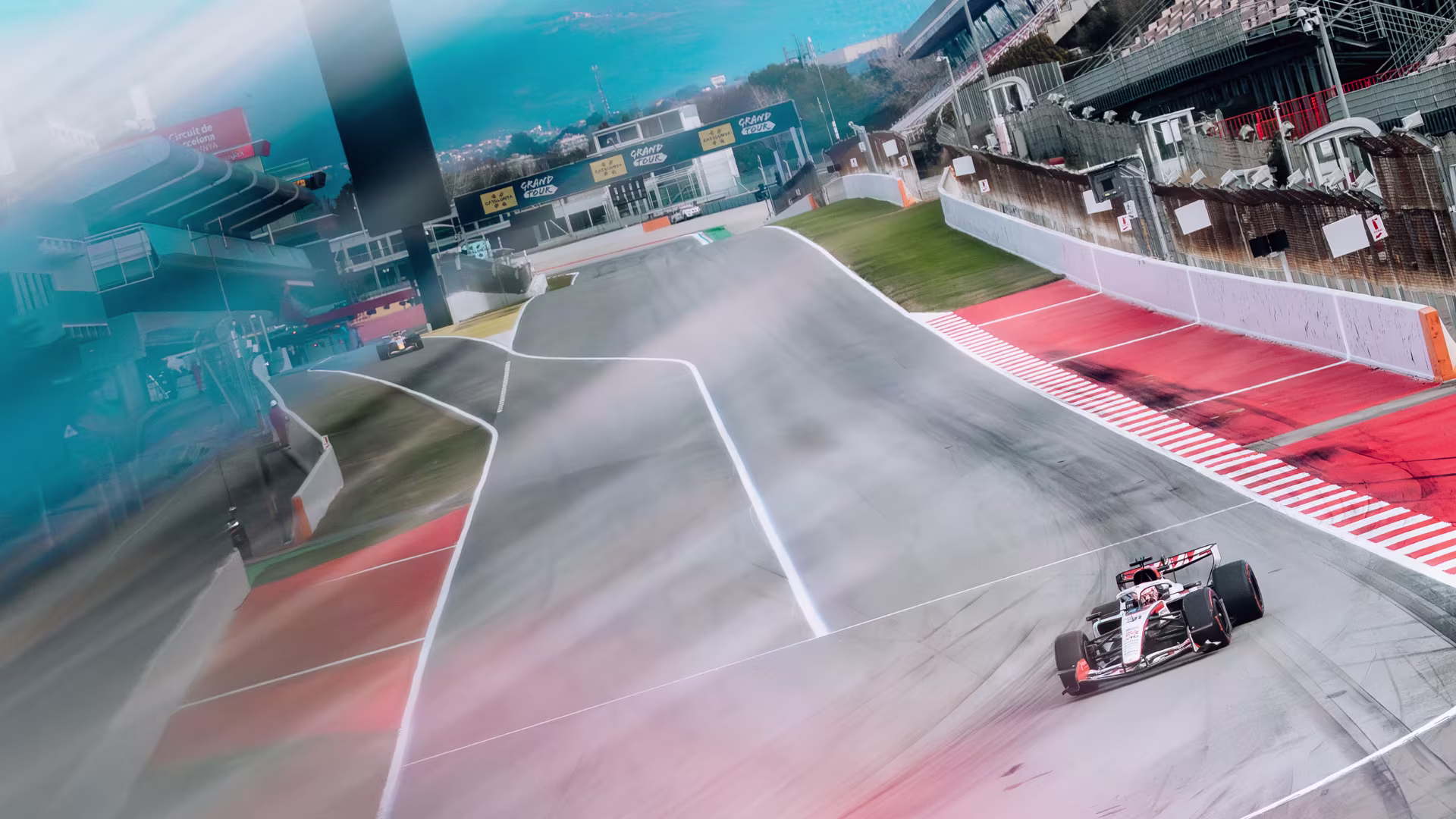 Auto F1 2026 en pista Barcelona Shakedown 2026, movimiento borroso en curva bajo cielo azul.