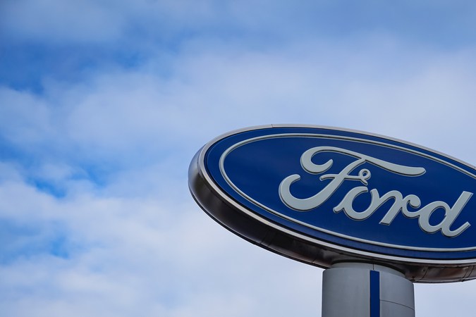 Cartel de la compañía Ford con fondo en el cielo