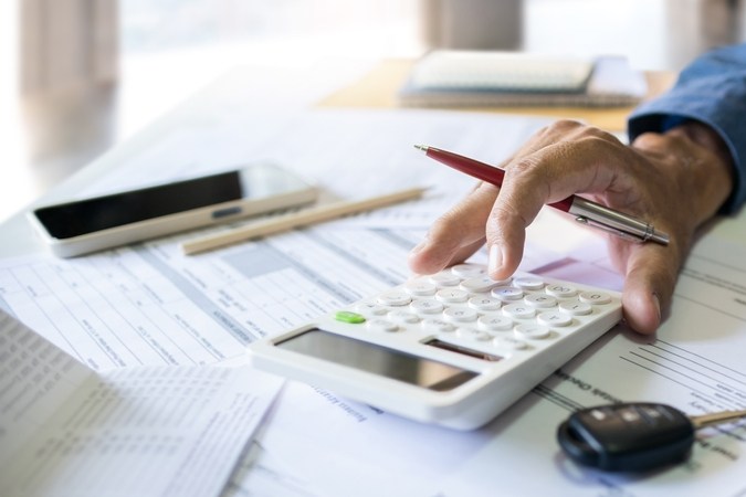 La mano de los hombres calcula las cuotas mensuales y comprueba el pasaporte y el extracto bancario antes de solicitar préstamos de coche para resolver problemas financieros en los negocios