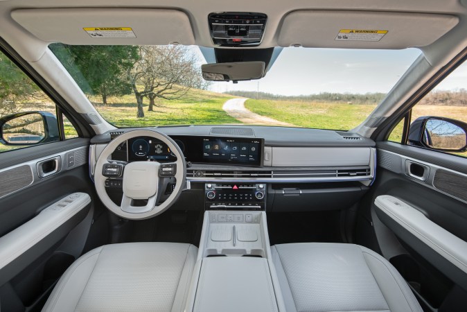 Interior Hyundai Santa Fe 2026 con pantallas curvas duales, volante premium y vista panorámica, cabina lujosa familiar.