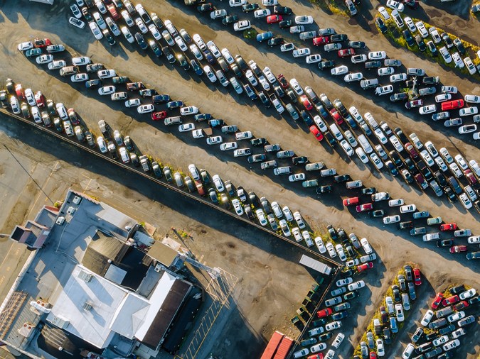 Vista aérea superior de la subasta de autos muchos estacionamientos de autos usados distribuidos en un estacionamiento.