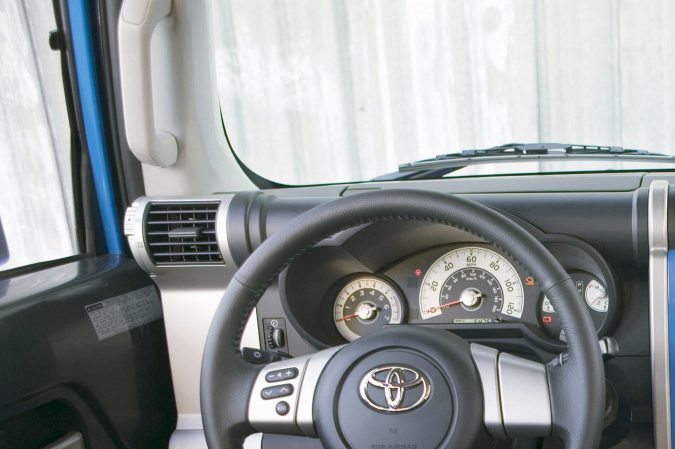 Interior azul Toyota FJ Cruiser 2008 con volante y tablero moderno, vista detallada cabina SUV off-road retro.