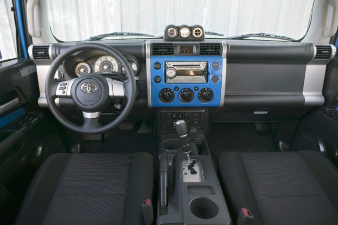 Interior azul Toyota FJ Cruiser 2008 con volante y tablero moderno, vista detallada cabina SUV off-road retro.