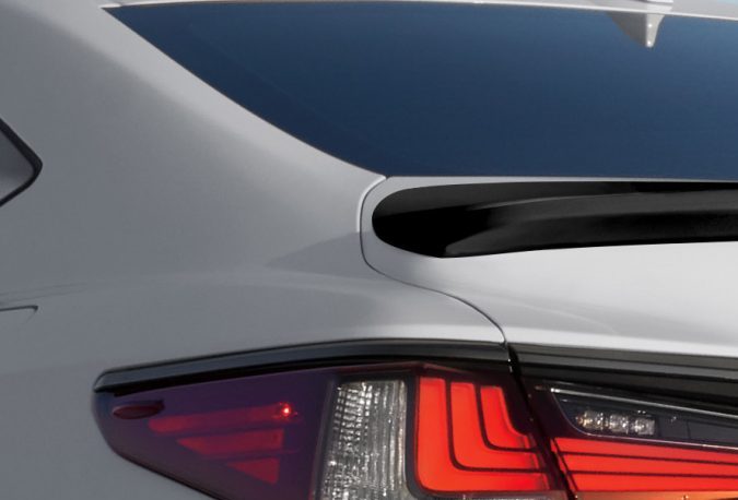 Detalle trasero del Lexus ES F Sport con alerón negro, luces LED rojas y emblema F SPORT en blanco sobre carrocería clara