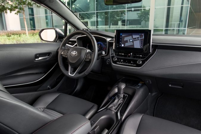 Interior Toyota Corolla 2026 XSE con volante, pantalla táctil y asientos negros en concesionario moderno