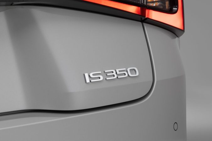 Emblema IS 350 en la parte trasera de un Lexus 2026 gris, detalle para contenido SEO sobre gama Lexus IS y futuras versiones eléctricas.