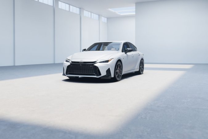 Lexus IS 350 2026 blanco en estudio, frontal agresivo con gran parrilla y rines deportivos, sedán de lujo ideal para contenido sobre autos deportivos.