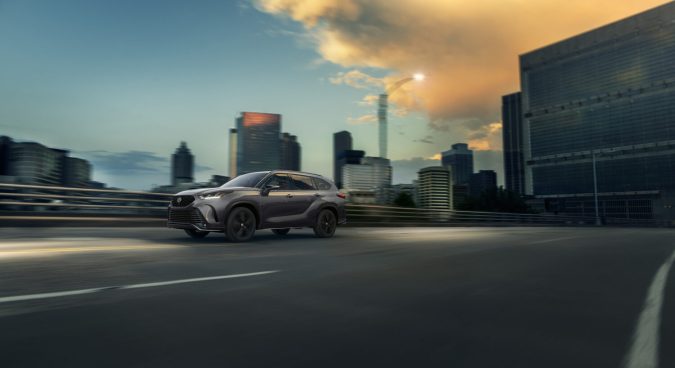 SUV Toyota nuevo modelo tres filas en ciudad al atardecer, diseño exterior moderno y versátil.