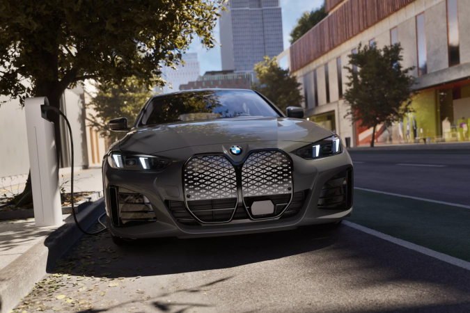 BMW i4 2026 Gran Coupé gris perfil delantero en paisaje soleado, parrilla icónica y líneas deportivas