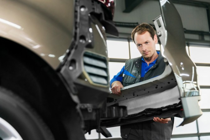 Mecánico inspecciona camioneta eléctrica Ford en el taller