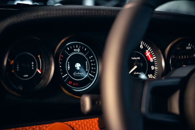 Detalles interiores Kalmar 7-97 Turbo, volante y medidores analógicos en cockpit Porsche 930 restomod exclusivo.