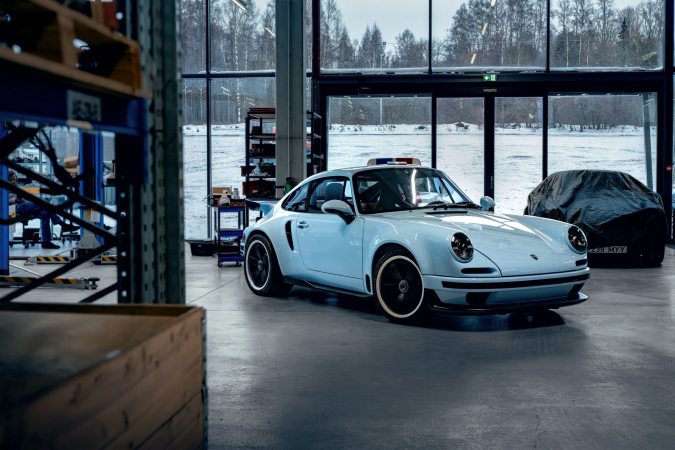 Porsche Kalmar 7-97 Turbo en taller moderno, vista frontal de restomod con 650 CV y fibra de carbono.
