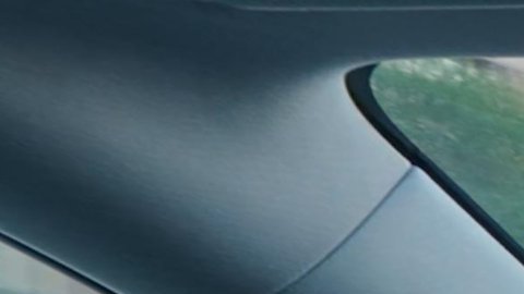 Vista interior Tesla conduciendo con FSD activado en pantalla central, IA autónoma avanzada y volante mínimo, autos eléctricos inteligentes 2026.