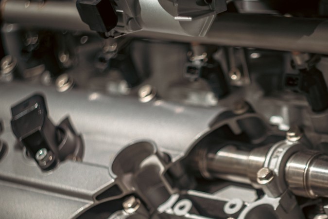 Primer plano de un motor de coche mostrando intrincados componentes metálicos y detalles de ingeniería.