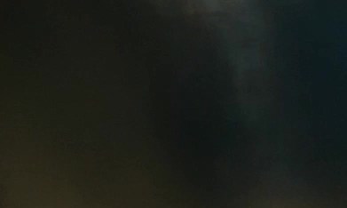 Mano masculina que sostiene la rueda en coche. El conductor masculino golpea sus dedos en el volante mientras conduce por la noche. Hermosas luces de la ciudad sobre fondo borroso. Estilo de lujo. Concepto nocturno