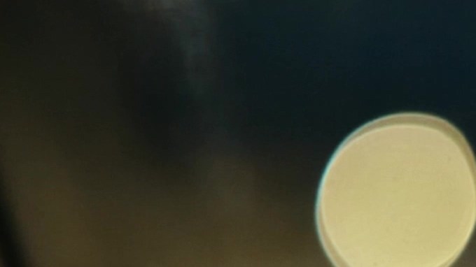 Mano masculina que sostiene la rueda en coche. El conductor masculino golpea sus dedos en el volante mientras conduce por la noche. Hermosas luces de la ciudad sobre fondo borroso. Estilo de lujo. Concepto nocturno