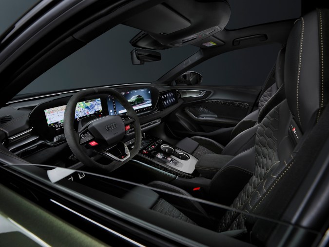 Cabina Audi RS5 Sedan vista frontal con cluster digital, pantalla central y pedales deportivos, innovación en vehículos de alto rendimiento