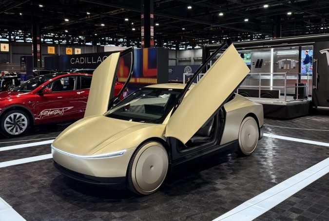 Tesla Cybercab dorado con puertas mariposa en booth Chicago Auto Show 2026