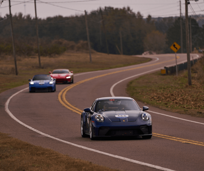 Porsche 911 GT3 azul lidera hypercars Ferrari en pista 1000 Miglia Experience Florida 2026.