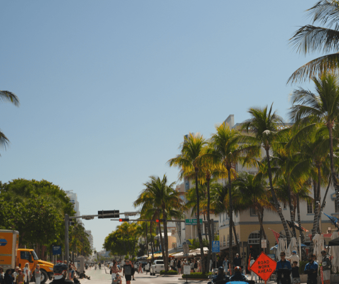 Desfile autos clásicos Ocean Drive Miami 1000 Miglia Florida, palmeras y edificios Art Deco.