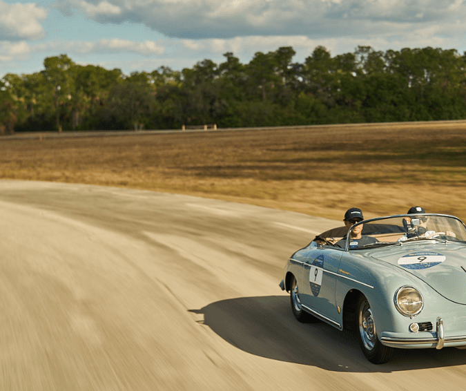 Porsche 356 Speedster azul en rally 1000 Miglia Florida 2026, curva rural soleada.
