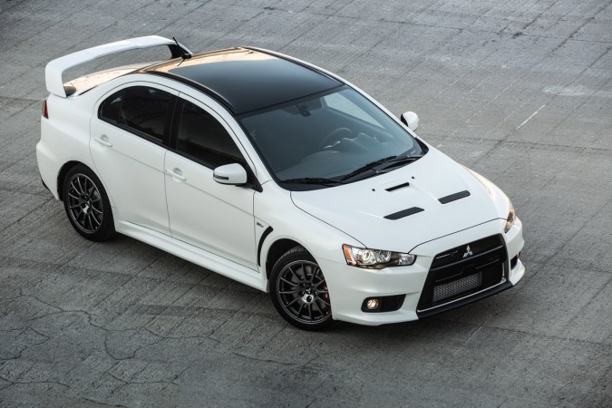 Lancer Evolution 2015 blanco con alerón, vista superior en estacionamiento, auto deportivo Mitsubishi premium.