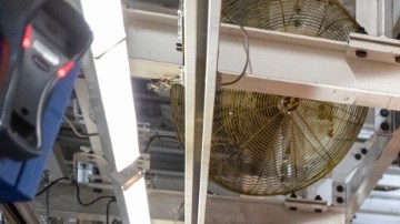 Línea de ensamblaje Ford Bronco en fábrica, producción de SUV todoterreno gris con estructura trasera visible, proceso industrial de manufactura automotriz de Ford