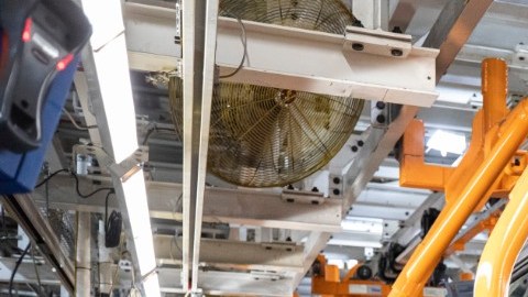 Línea de ensamblaje Ford Bronco en fábrica, producción de SUV todoterreno gris con estructura trasera visible, proceso industrial de manufactura automotriz de Ford