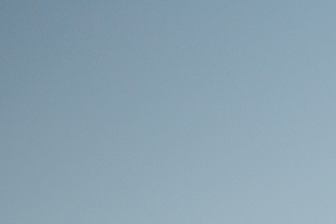 Vista trasera del Nissan Z 2027 NISMO en gris, con alerón y rines deportivos junto al mar, destacando diseño renovado.