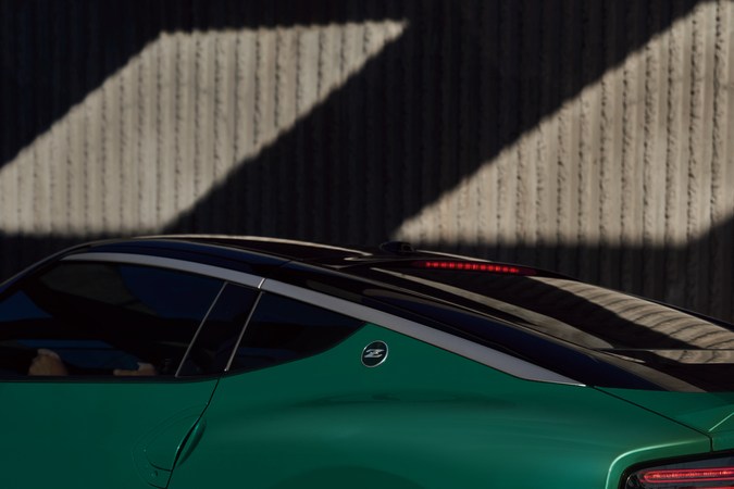 Vista trasera del Nissan Z NISMO 2027 manual en verde, con difusor, luces LED y alerón en entorno urbano al atardecer.