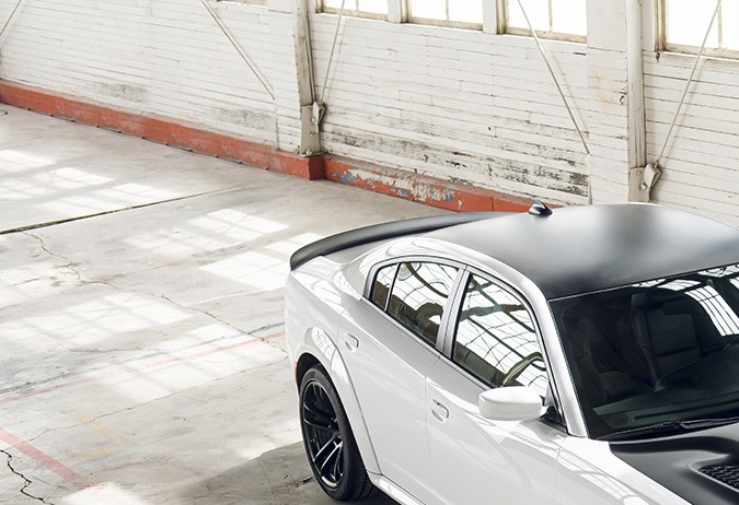 Dodge Charger SRT Hellcat Redeye blanco en pista, drift agresivo al atardecer, muscle car deportivo de alto rendimiento, potencia V8 supercargada.