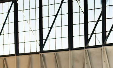 Hyundai Venue 2026 gris estacionado en angar accesible más barato América vista lateral.