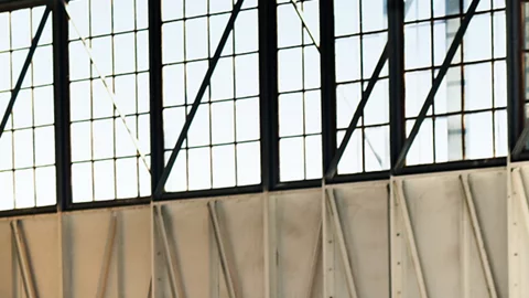 Hyundai Venue 2026 gris estacionado en angar accesible más barato América vista lateral.