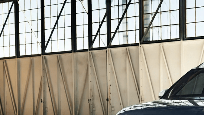 Hyundai Venue 2026 gris estacionado en angar accesible más barato América vista lateral.