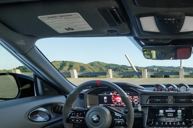 Interior del Nissan Z 2027 con volante deportivo, pantallas digitales y asientos de alto desempeño en cabina enfocada al conductor.
