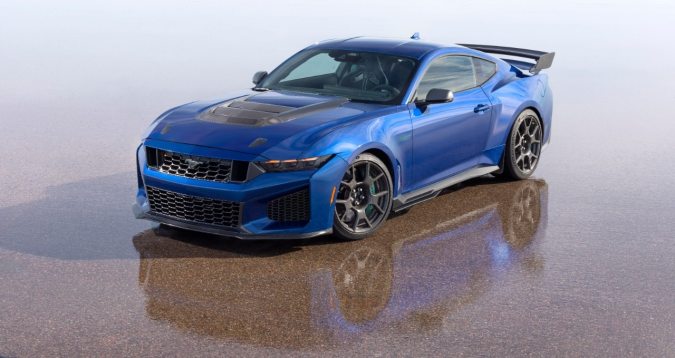 Ford Mustang Dark Horse SC Track Pack azul en ángulo tres cuartos frontal, carrocería ensanchada, cofre de fibra de carbono y rines deportivos listos para circuito.