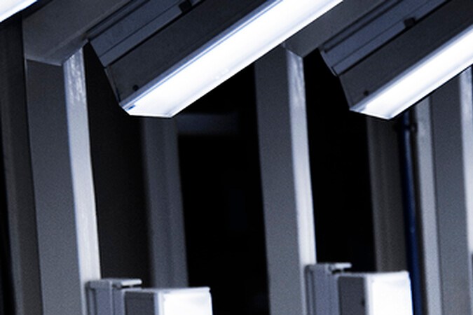 Vista frontal Alpine A110 nuevo azul en túnel luces, futuro deportivo eléctrico en Estados Unidos.