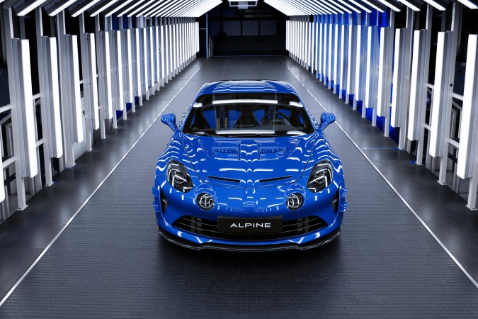 Vista frontal Alpine A110 nuevo azul en túnel luces, futuro deportivo eléctrico en Estados Unidos.