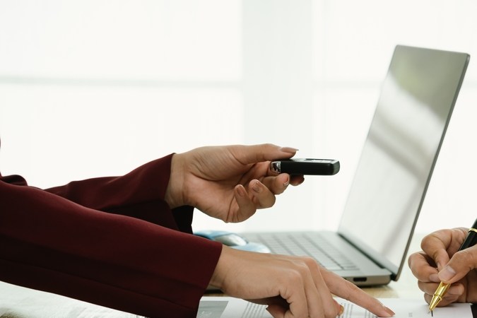 Un hombre de negocios y un cliente completan un Acuerdo firmando documentos para el seguro de automóvil, préstamo o alquiler, simbolizando finanzas, contratos, pólizas, inversiones, compras, trámites legales y propiedad segura