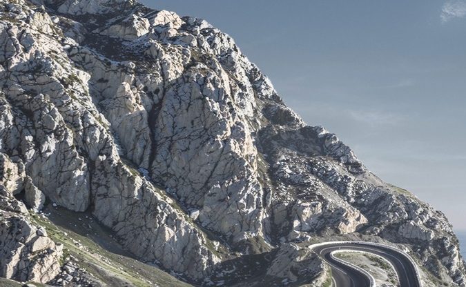 BMW i3 2027 Neue Klasse azul en carretera costera con vistas al mar, diseño eléctrico premium y curvas dinámicas