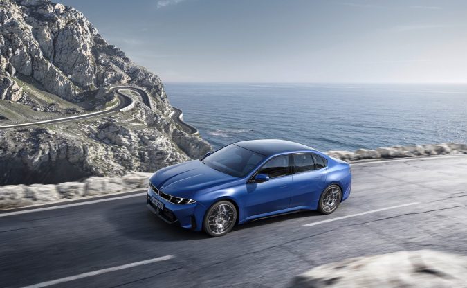 BMW i3 2027 Neue Klasse azul en carretera costera con vistas al mar, diseño eléctrico premium y curvas dinámicas