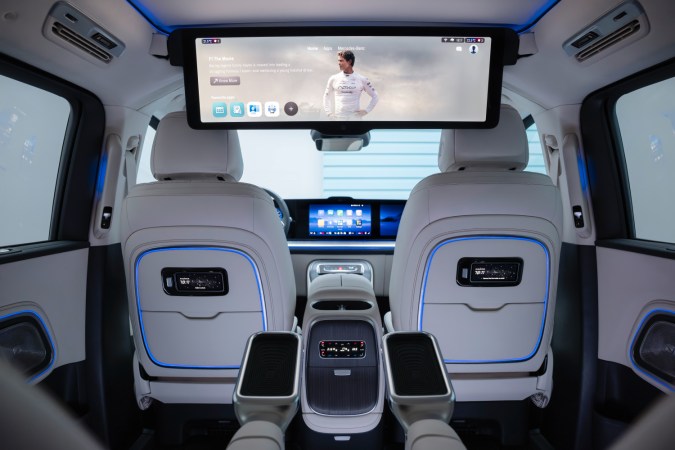 Interior del Mercedes-Benz VLE 300 eléctrico, con asientos lujosos, pantallas grandes y espacio para 8 pasajeros.