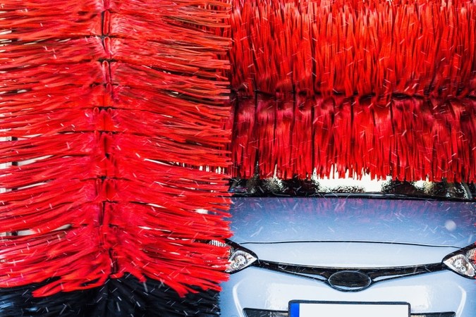 Lavadora automática limpie el coche azul en la estación de lavado automático. Fondo automático de lavadora de coches